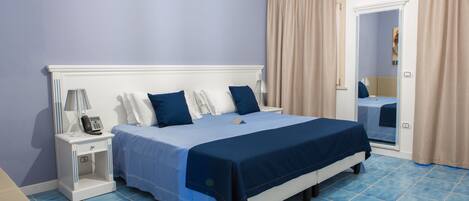A bedroom with a bed, nightstand, and a mirror.