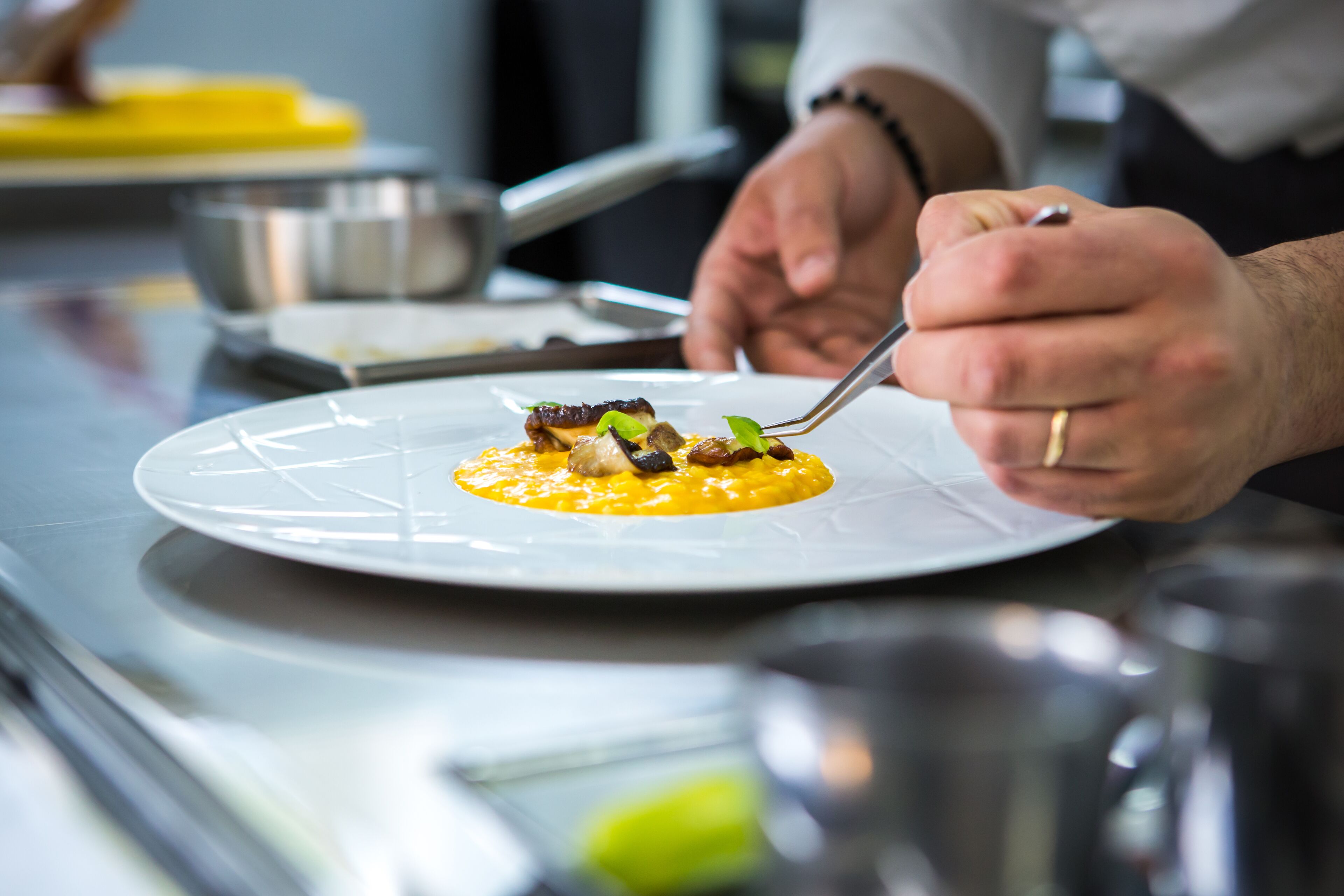 Une personne est assise à une table dans un restaurant, avec une assiette de nourriture devant elle.