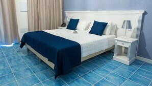 A hotel room with a bed, nightstands, and a blue tiled floor. - Galìa Luxury Resort (Pizzo)