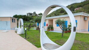 A modern outdoor seating area with unique white, curved structures. - Galìa Luxury Resort (Pizzo)