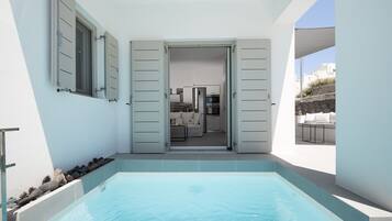 Una piscina al aire libre, sillones reclinables de piscina