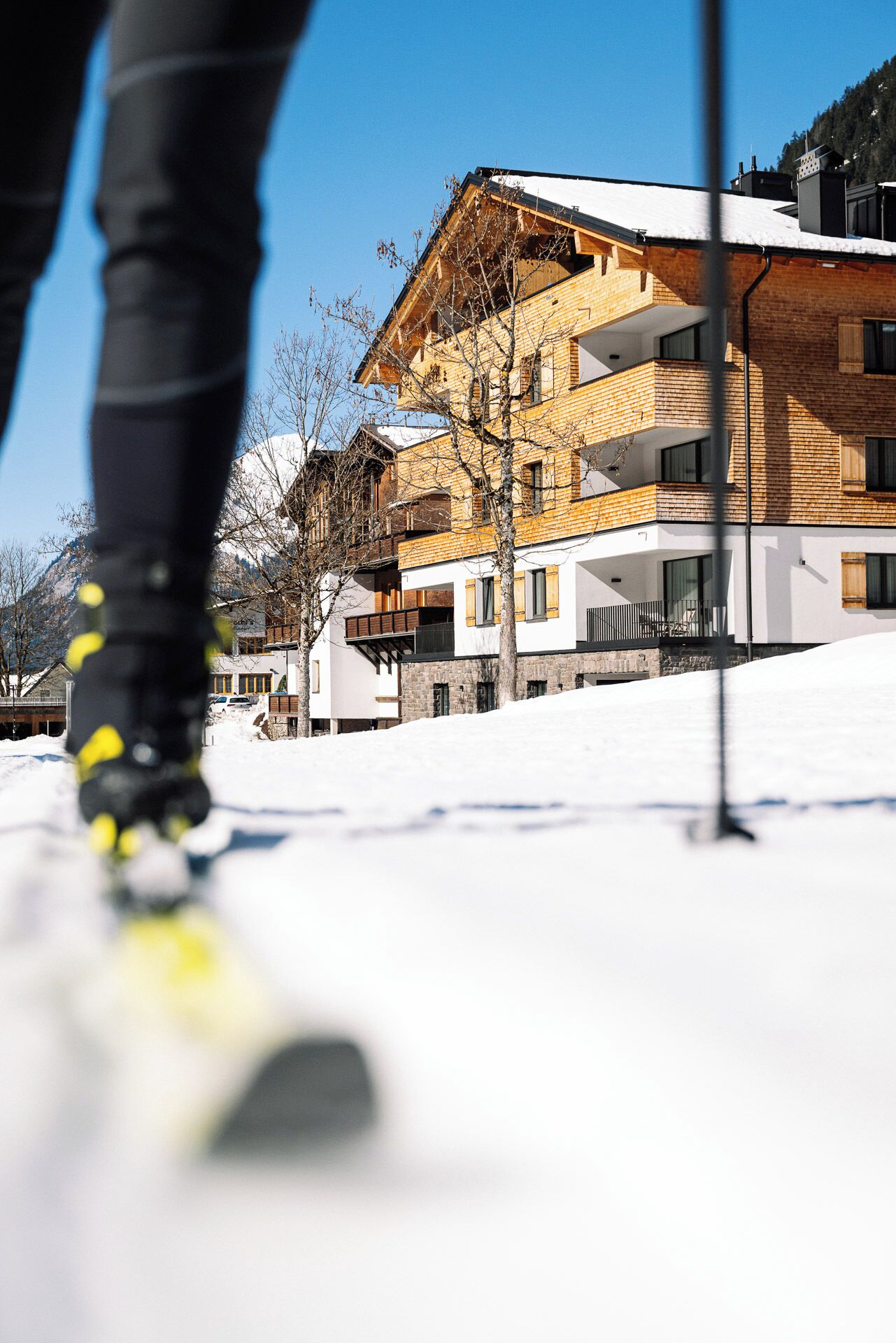 A ski resort building with multiple balconies and a snow-covered ground.