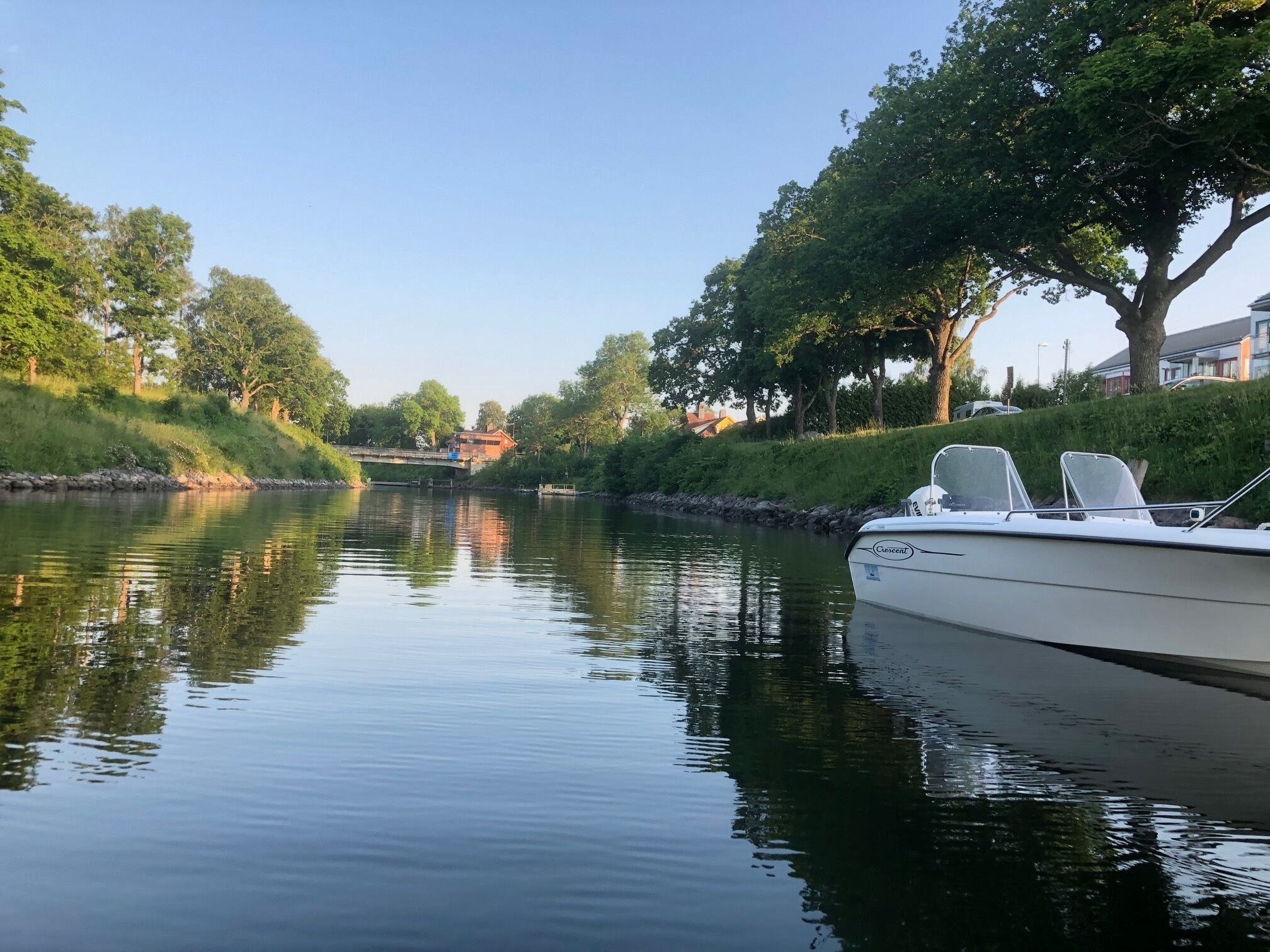 Un río tranquilo con una barca amarrada a la derecha.