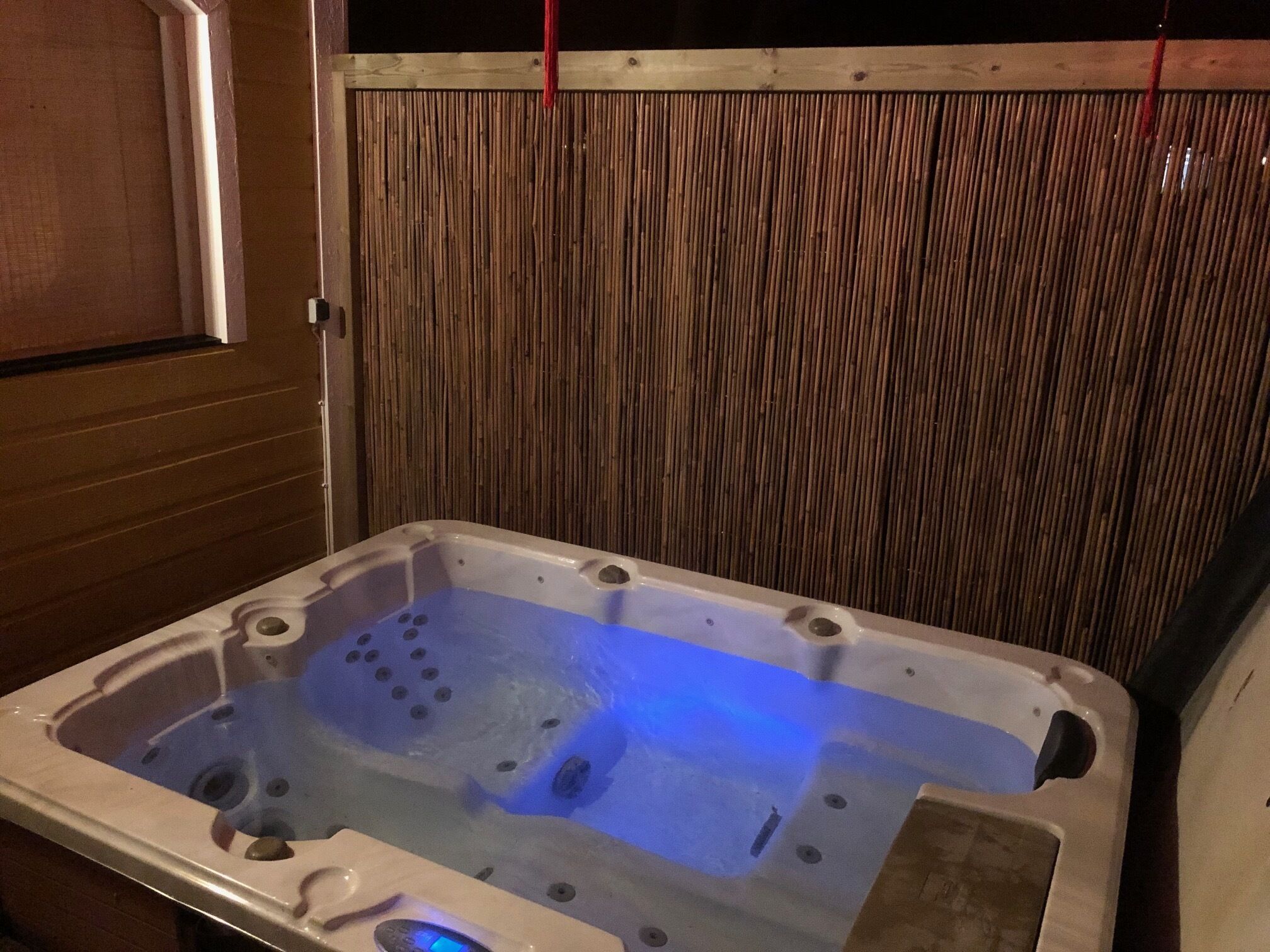 Un jacuzzi con fondo de madera y panel de control a la vista.