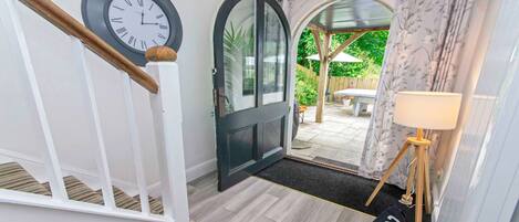 A staircase leading to a door with a clock, a rug, and a lamp.