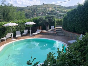 Piscine extérieure, parasols de plage, chaises longues