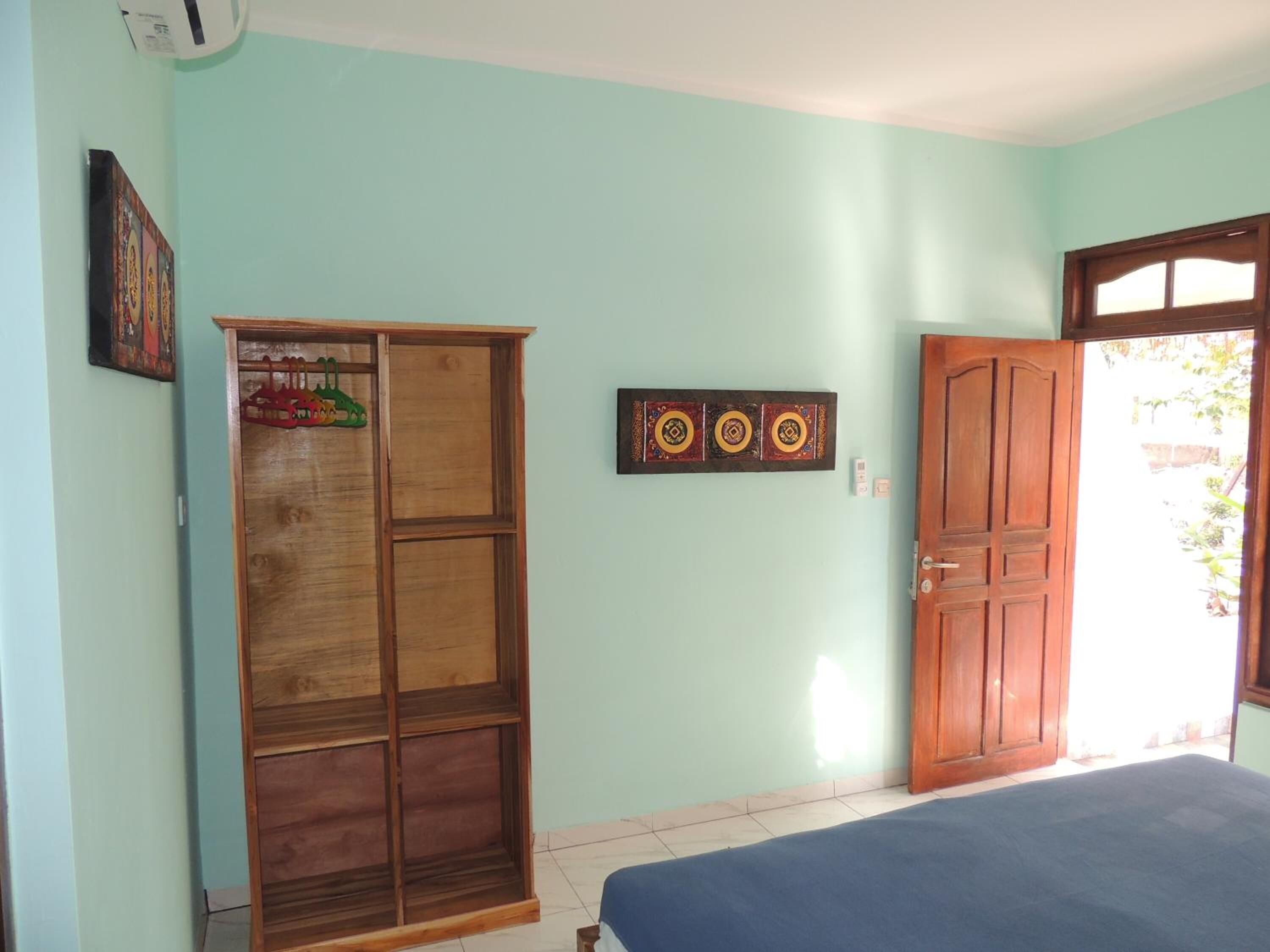Una habitación con una cama, un armario y una puerta.