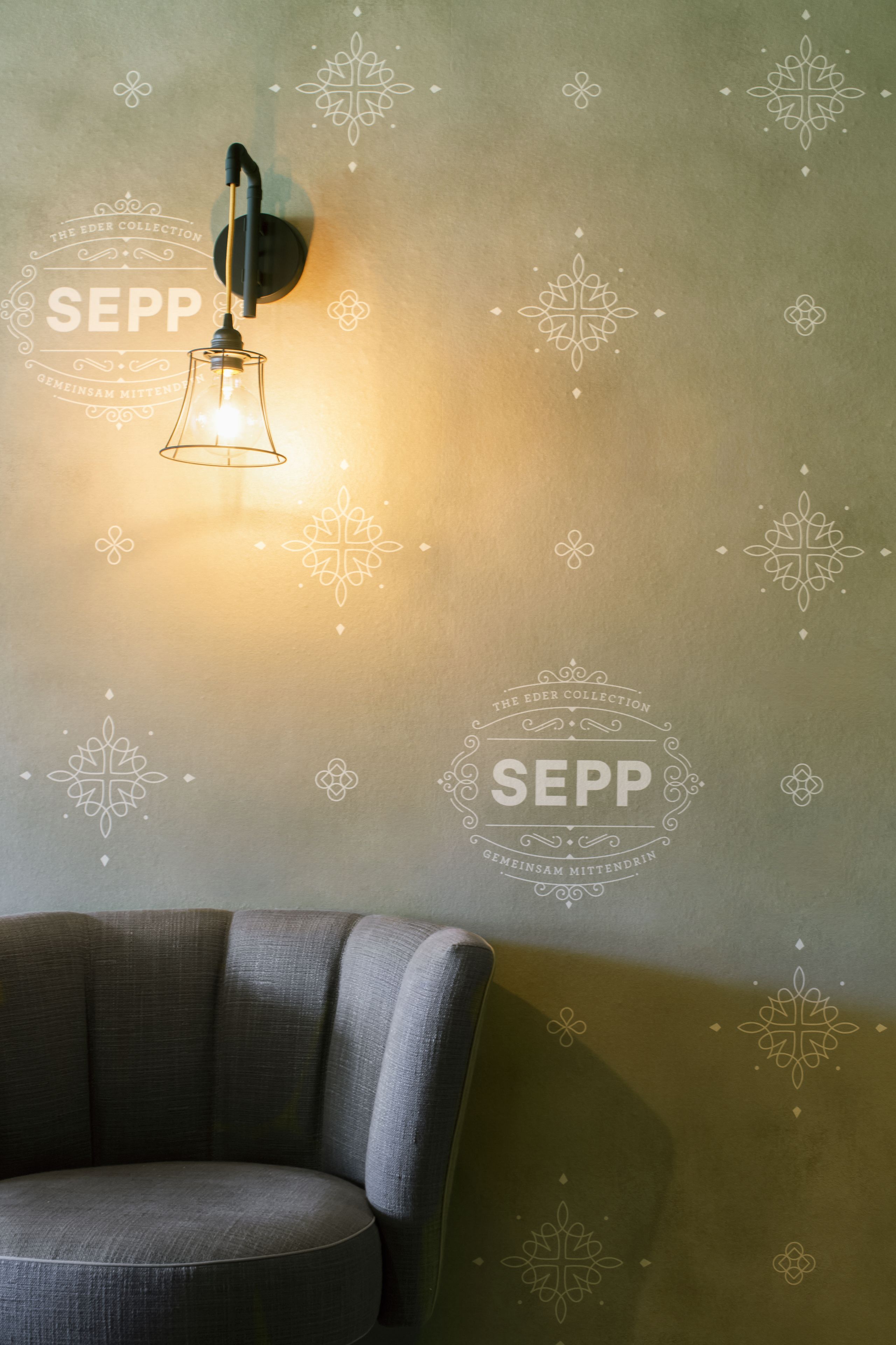 Un mur orné d’un luminaire décoratif et sur lequel est adossée une chaise.