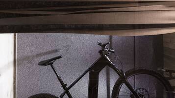 A bicycle mounted on a wall with a wooden panel above.