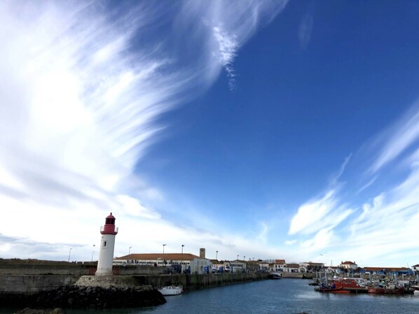 Une ville côtière dotée d’un phare, d’un port et de b âtiments situés le long du front de mer.