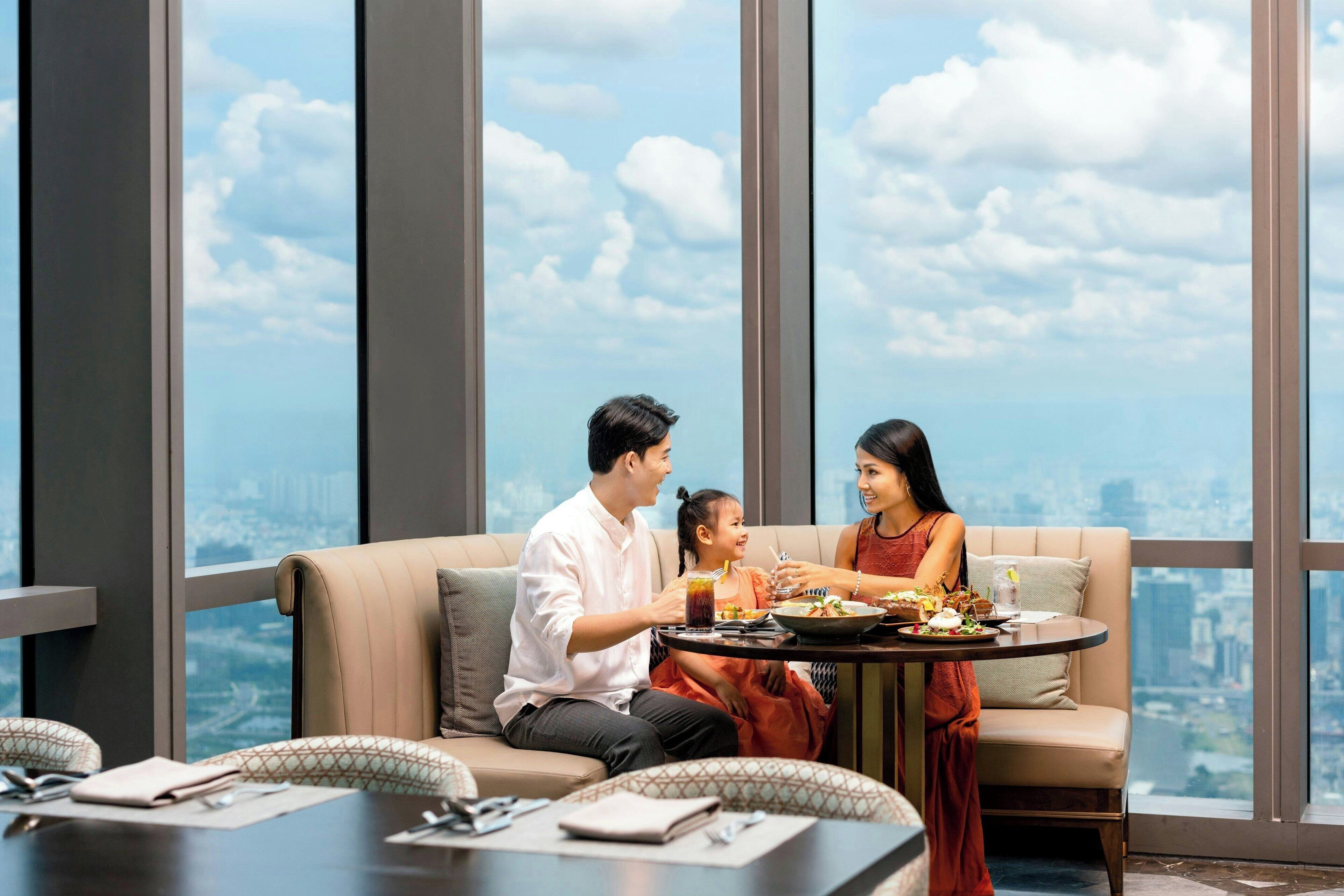 A dining area with a city view, a sofa, and a table with food and drinks.