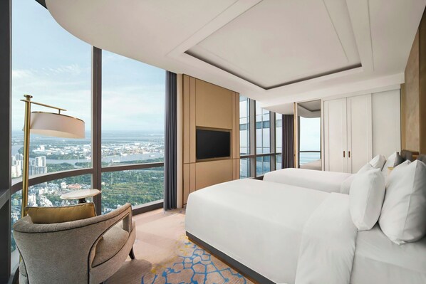 Une chambre d’hôtel moderne, dotée d’un grand lit, d’une télévision et offrant une vue sur la ville.