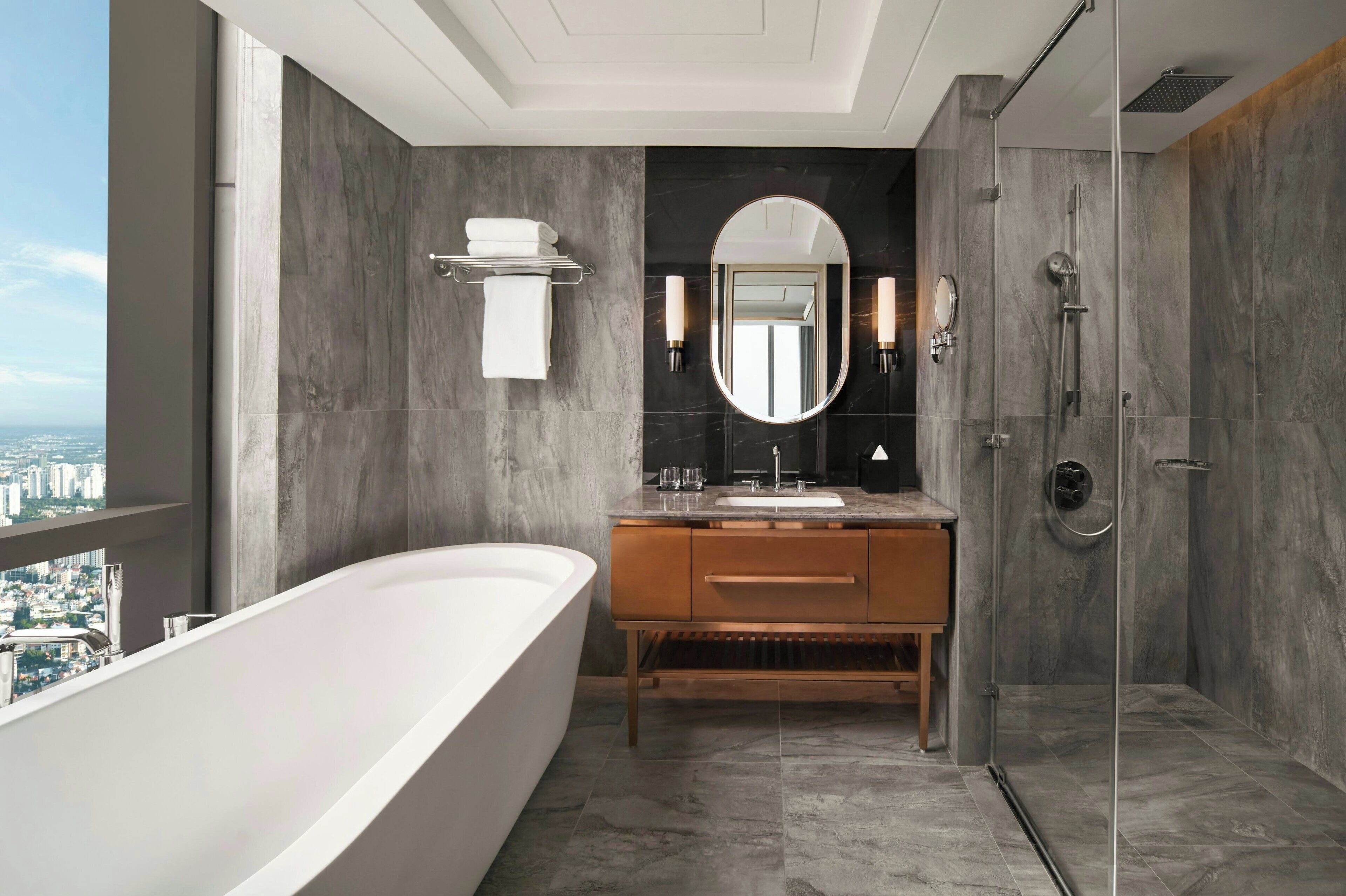 Un baño moderno con bañera, tocador con espejo y zona de ducha.