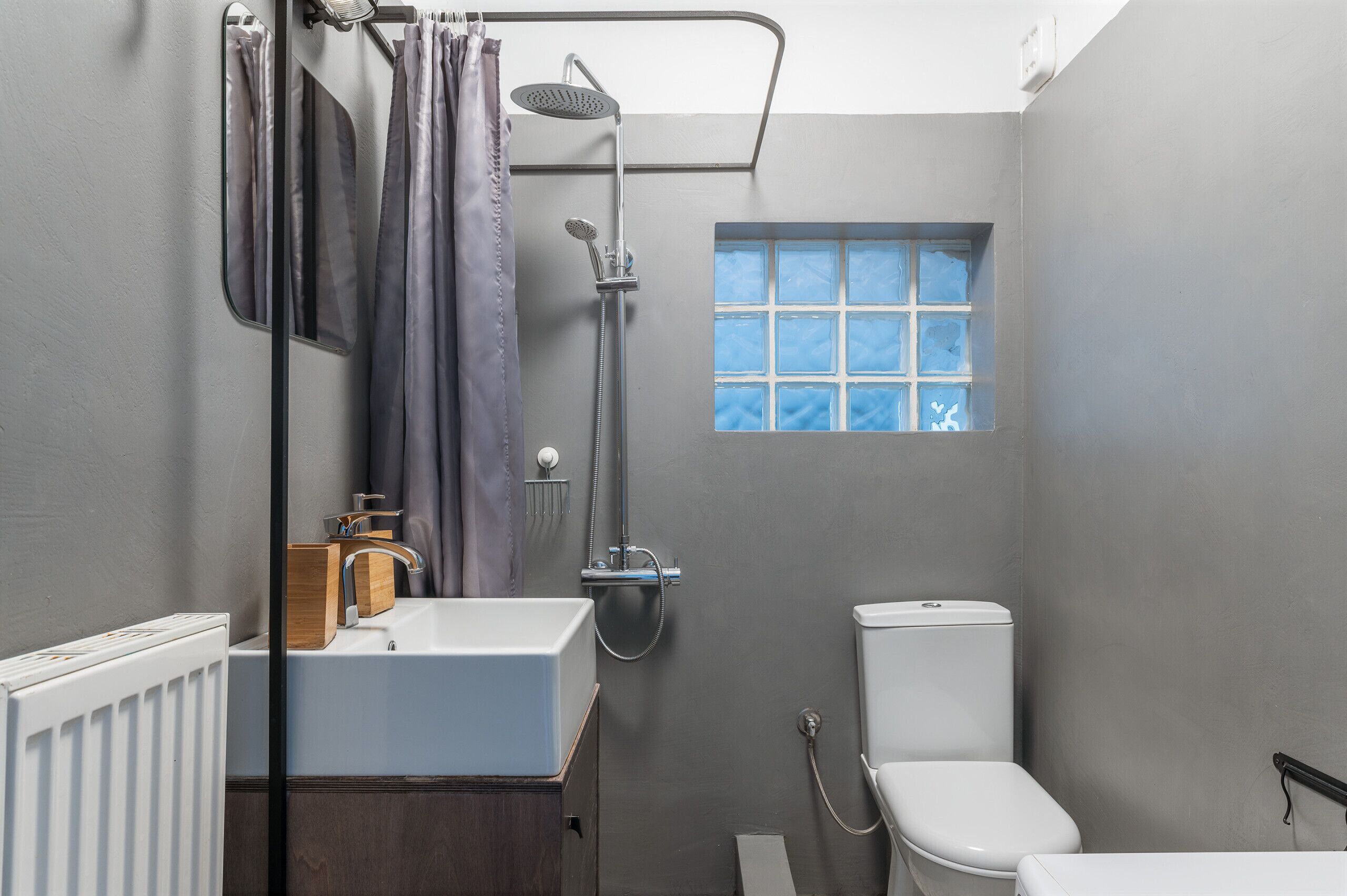 A compact bathroom with a shower, toilet, and sink.