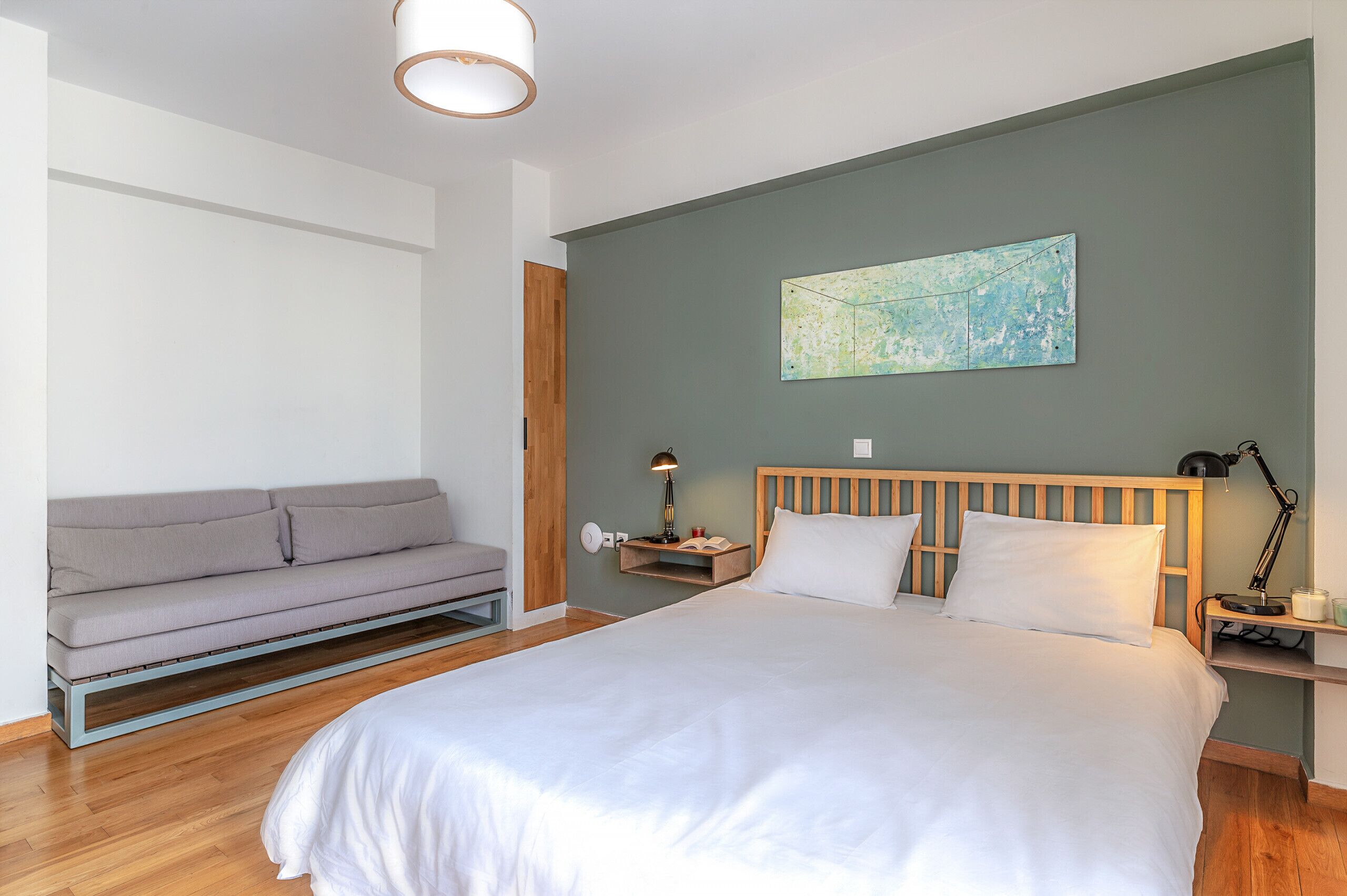 Une chambre à coucher moderne, avec un lit, un canapé, une table de chevet et une carte accrochée au mur.