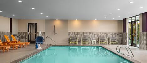 Une piscine avec des chaises longues et un vestiaire.