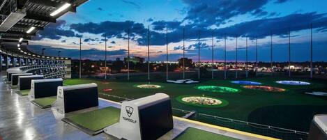 Et golf driving range med flere tee-spots og et godt oplyst træningsområde.