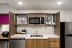 A modern kitchen with a built-in microwave, coffee maker, and stainless steel sink. - Home2 Suites by Hilton Portland Hillsboro (Hillsboro)