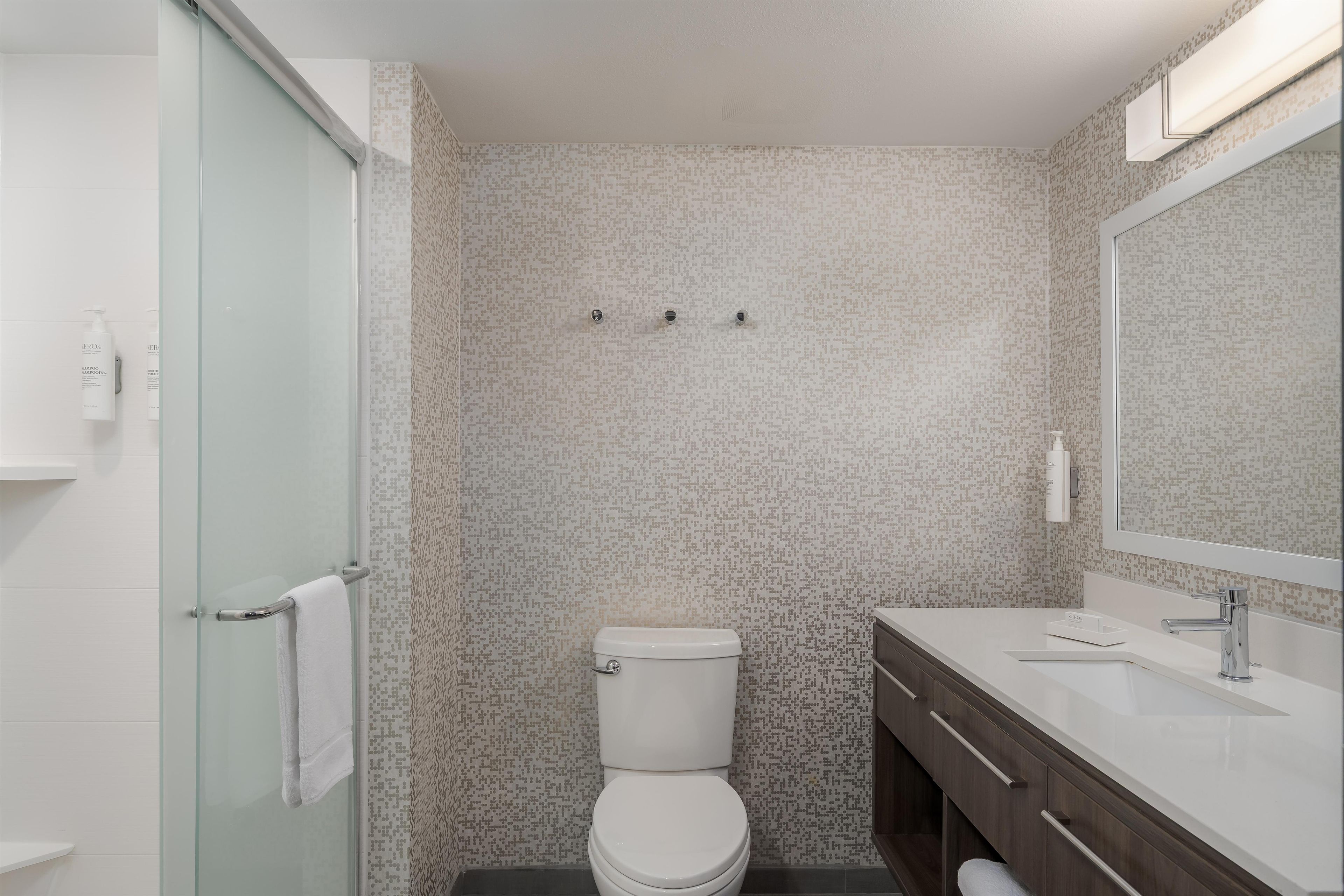A bathroom with a toilet, a sink, and a glass shower enclosure.