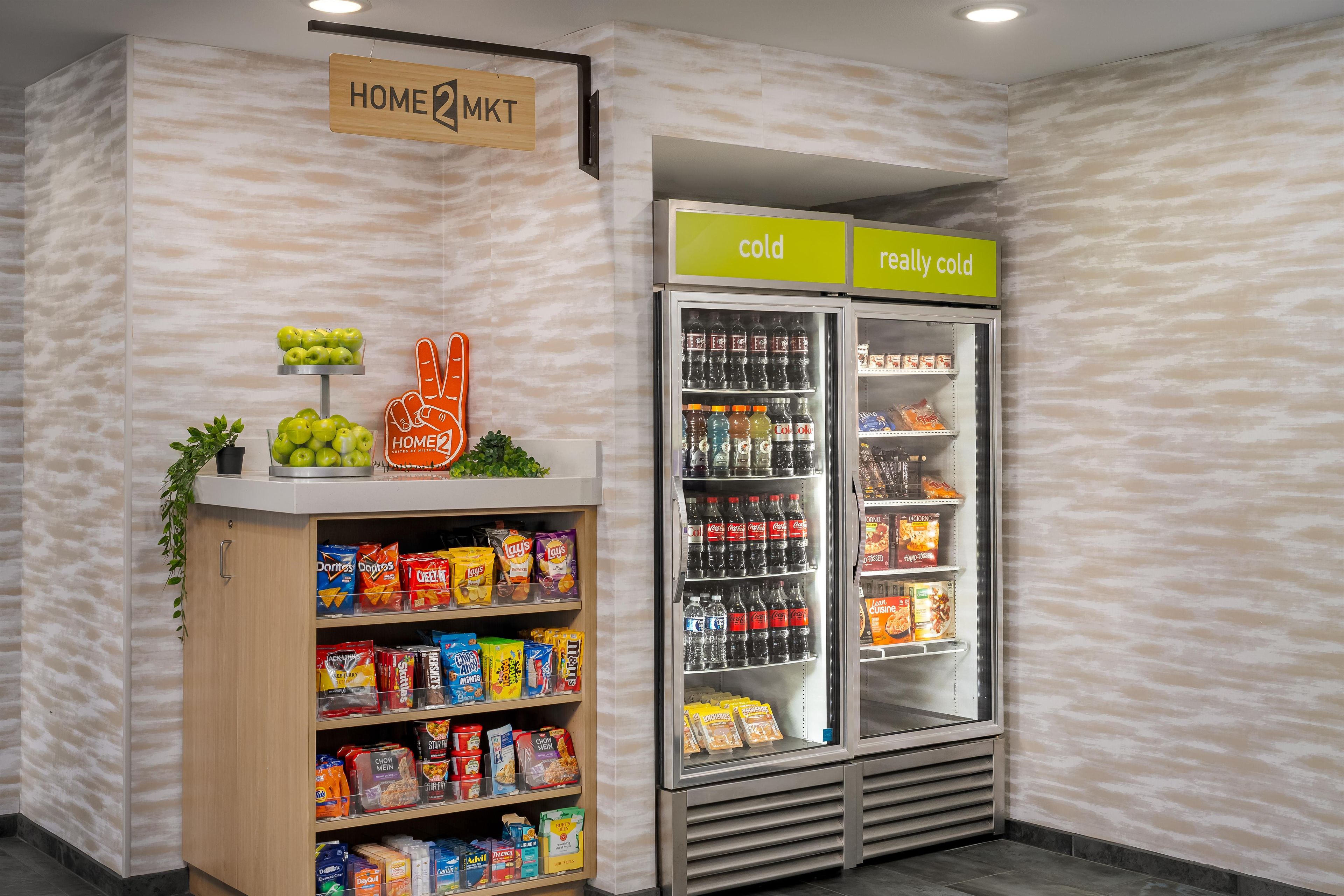 A snack display with various chips and snacks, a refrigerated section with beverages, and a sign indicating 'cold' and 'really cold' sections.