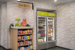 A snack display with various chips and snacks, a refrigerated section with beverages, and a sign indicating 'cold' and 'really cold' sections. - Home2 Suites by Hilton Portland Hillsboro (Hillsboro)