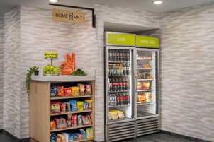 Mostrador de aperitivos con papas fritas y otros bocadillos, una sección refrigerada con bebidas, y un cartel que indica zonas 'frío' y 'muy frío'.