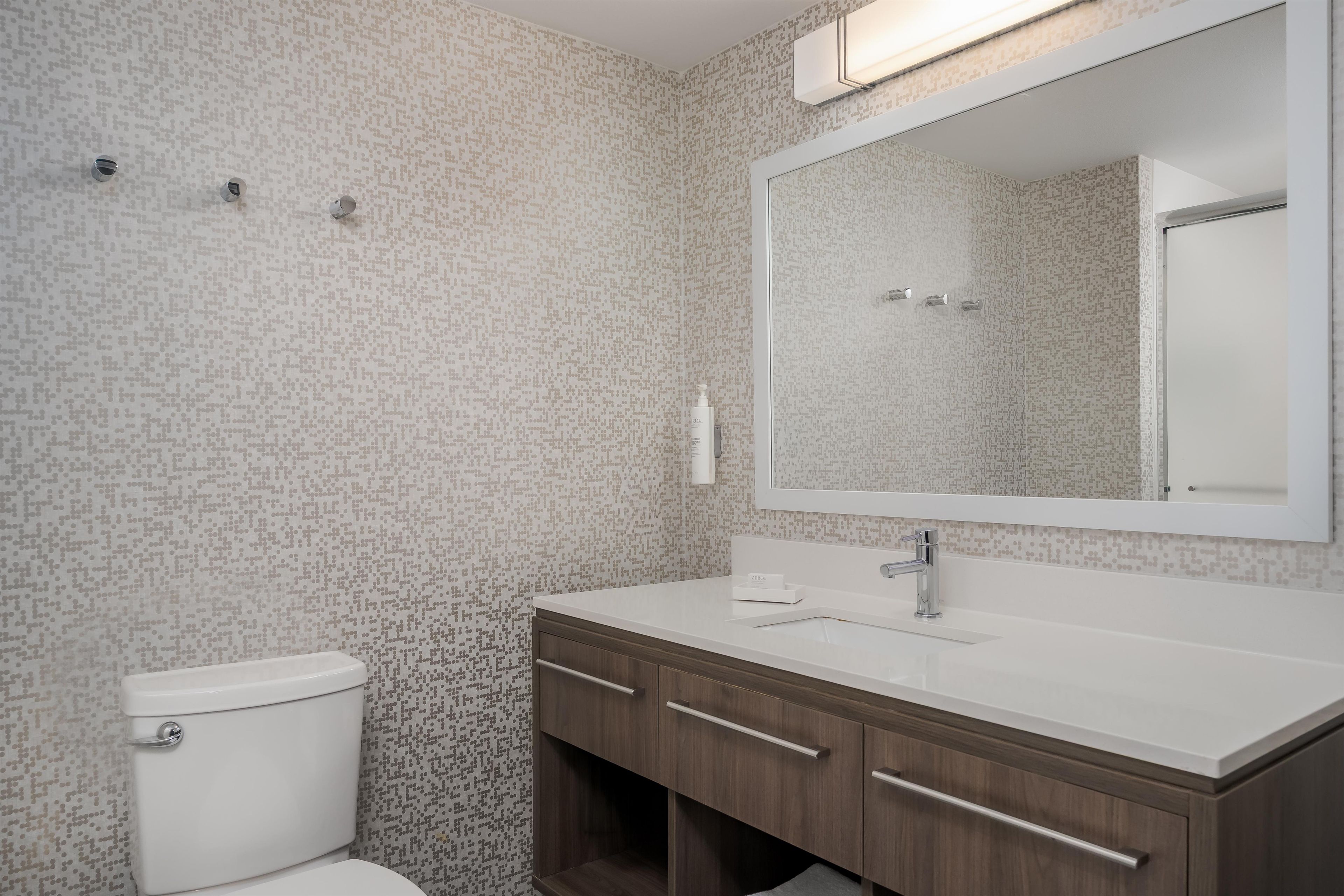 Un baño con inodoro, lavamanos y espejo.