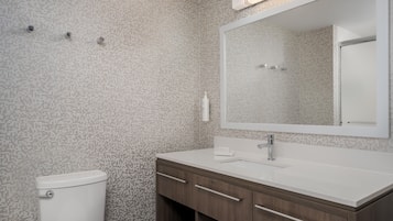 Un baño con inodoro, lavamanos y espejo.
