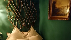 A bed with a decorative headboard and multiple pillows.