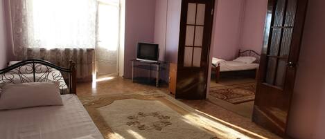 Habitación cuádruple económica | Cortinas blackout, tabla de planchar con plancha y camas extra