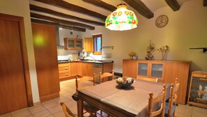 Un coin repas avec une table et des chaises en bois, un lustre et des meubles de rangement en bois.