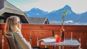 Une personne assise à une table, avec une vue sur les montagnes en arrière-plan.