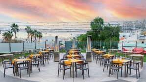 An outdoor dining area with multiple tables and chairs, arranged in a semi-circular pattern. - Santa Maria Aparthotel (Adeje)