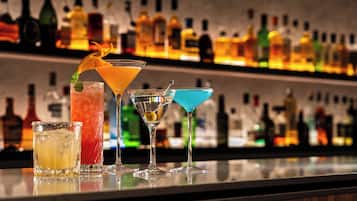A bar with various cocktails and bottles in the background.