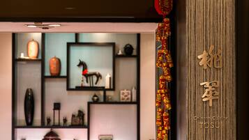 Un área de recepción con decoración tradicional china, que incluye un adorno colgante rojo y caracteres chinos en la pared.