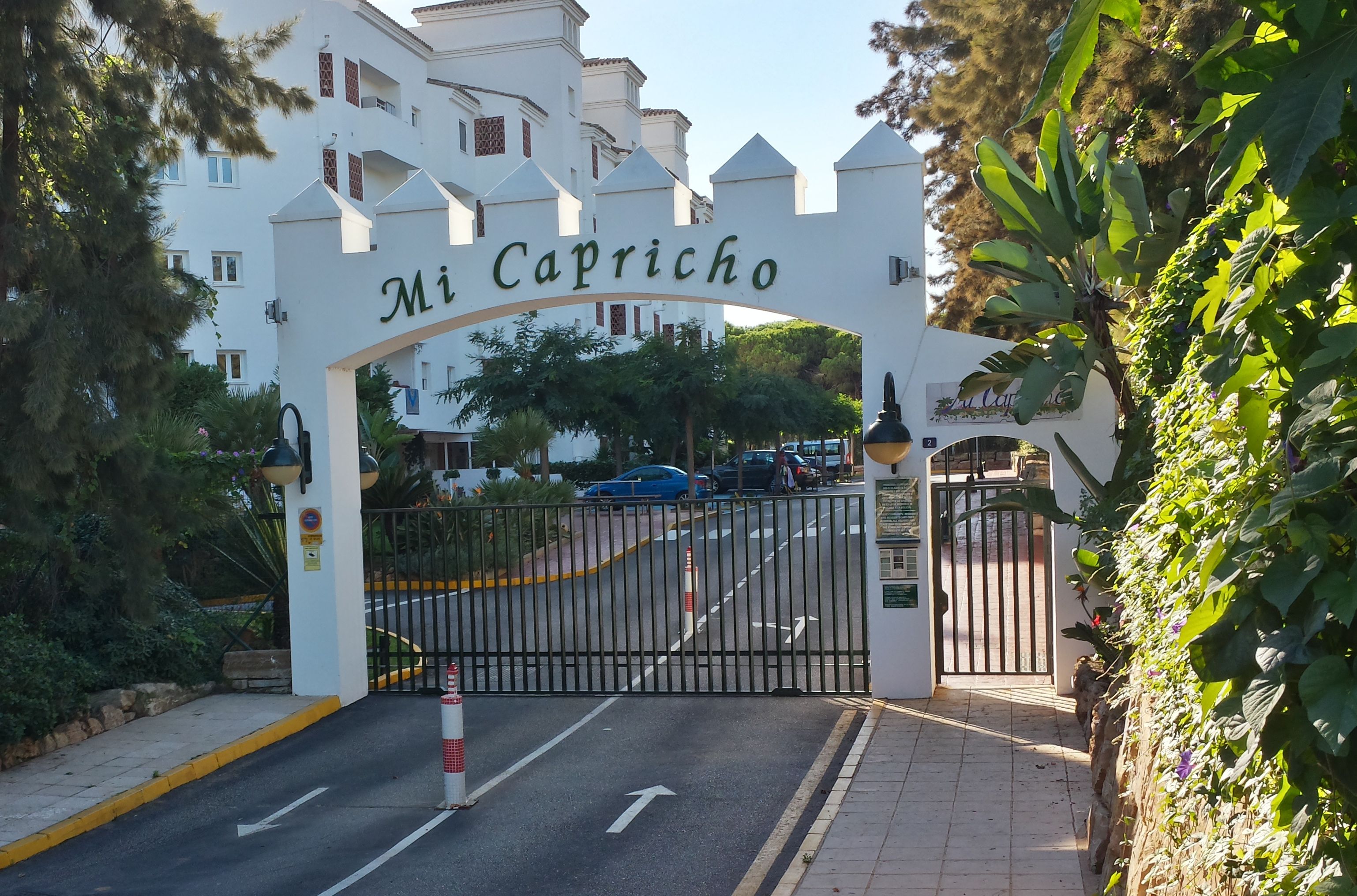 A gated entrance to a building with a sign reading "Mi Capricho."
