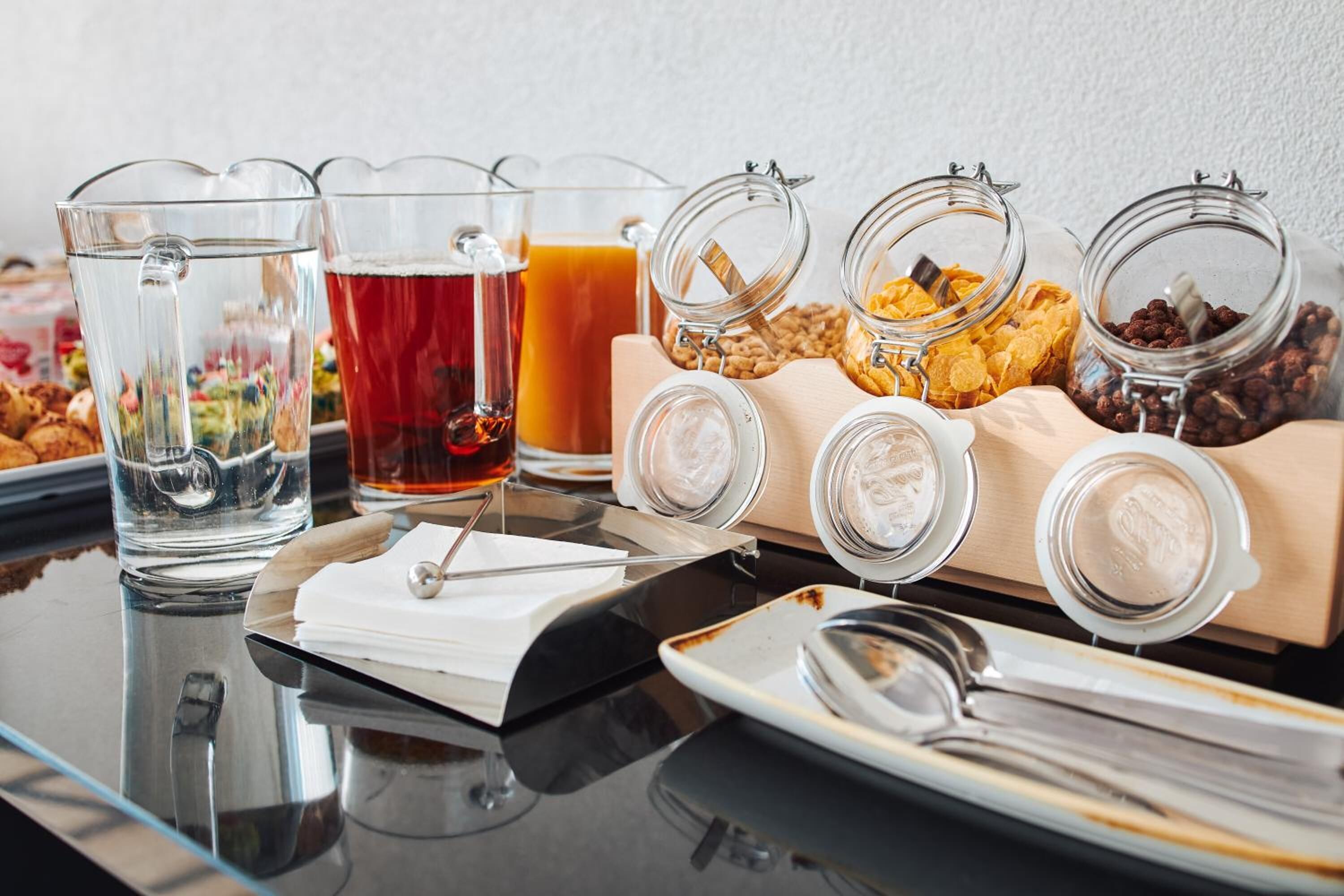 Una mesa de desayuno tipo buffet con diversos alimentos y bebidas.