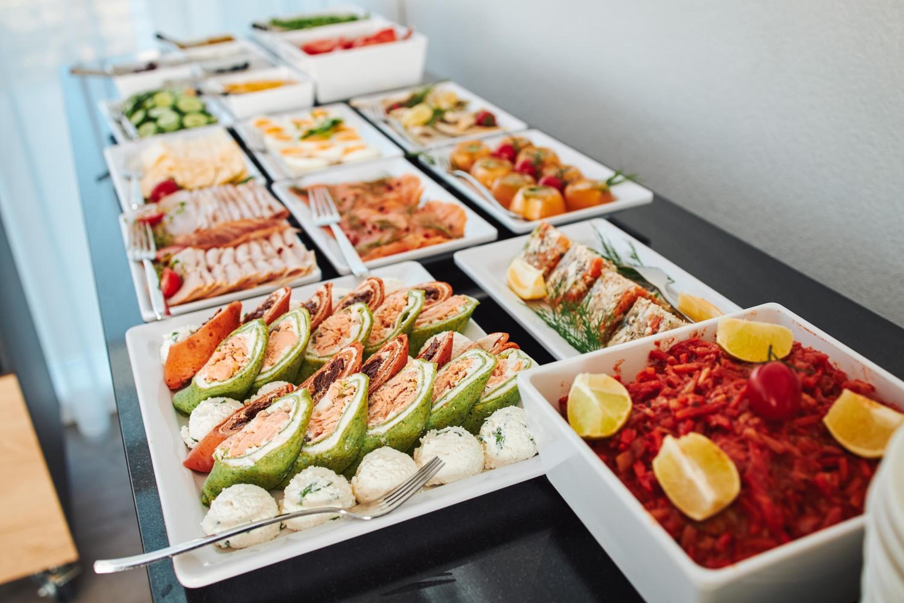 A buffet with various dishes including sushi, salads, and other prepared foods.