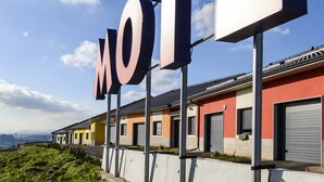 A motel with a large 'MOTEL' sign, modern buildings, and a clear sky. - Motel Cancún Avilés (Gozon)