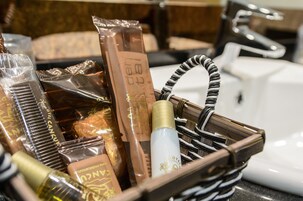 Una cesta con artículos de aseo personal y una botella de loción.