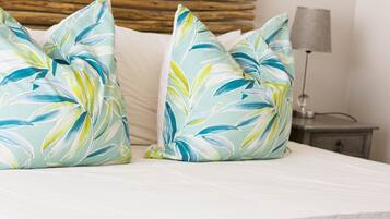 A bed with two decorative pillows and a bedside lamp.
