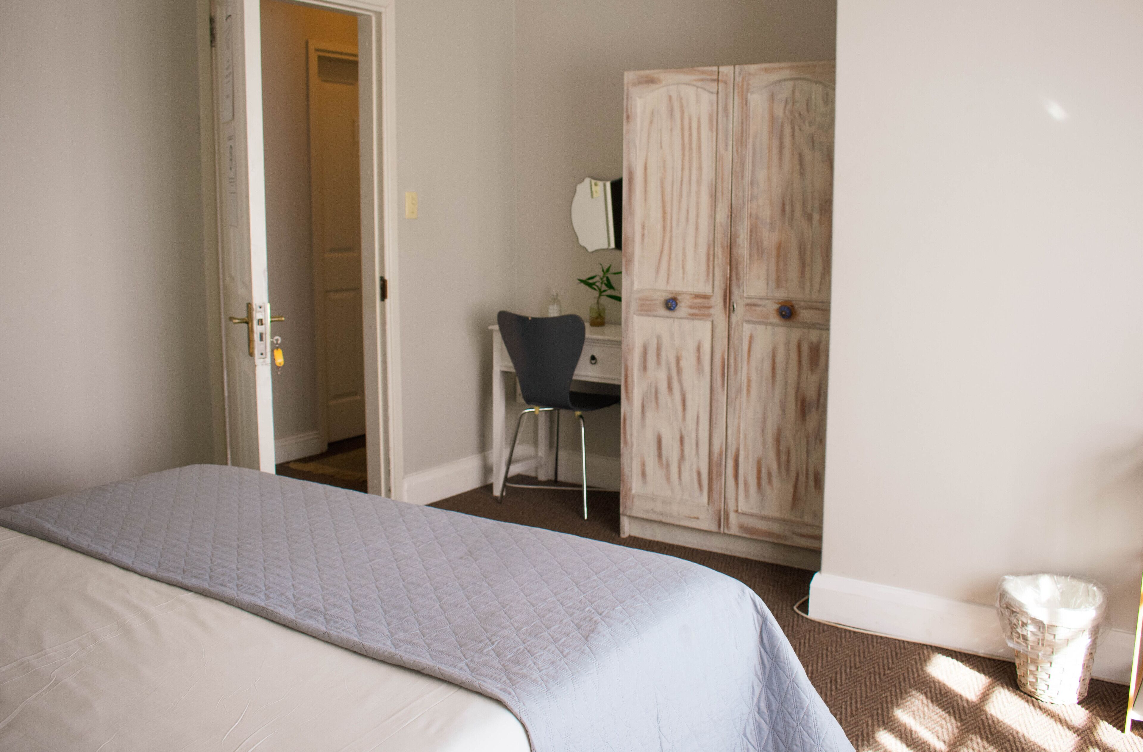 Une chambre à coucher avec un lit, un bureau et une armoire.