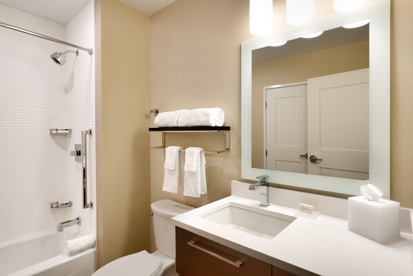 A modern bathroom with a shower, toilet, sink, and a mirror.