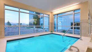 A swimming pool with clear blue water, large windows, and a view of a desert landscape. - TownePlace Suites by Marriott Salt Lake City Draper (Draper)