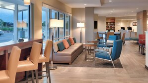 A modern hotel lobby with a bar area, seating, and a reception desk. - TownePlace Suites by Marriott Salt Lake City Draper (Draper)
