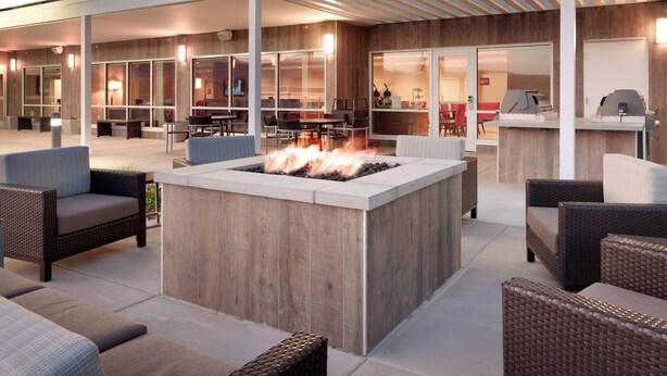 An outdoor seating area with a fire pit, wicker furniture, and a covered patio. - TownePlace Suites by Marriott Salt Lake City Draper (Draper)