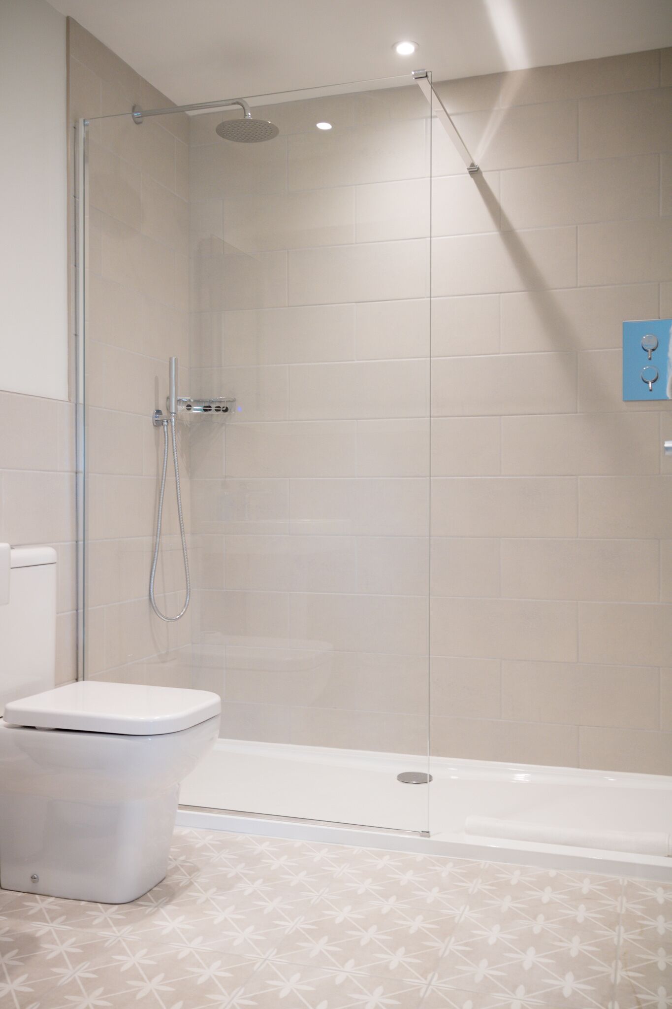 Un baño moderno con ducha envuelta en vidrio, inodoro blanco y bañera.