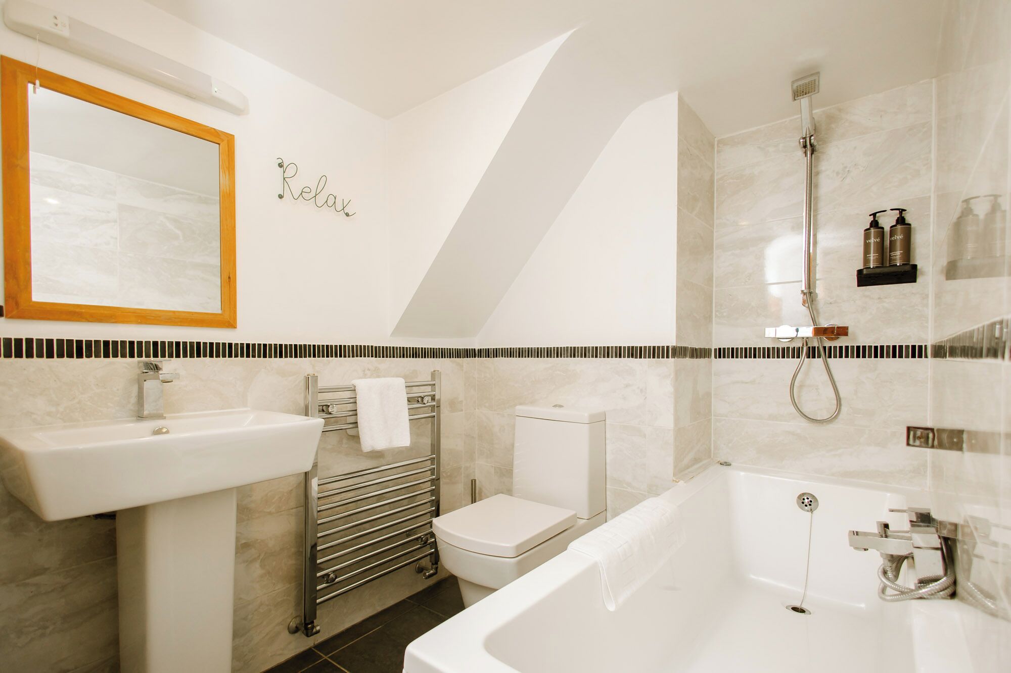 A modern bathroom with a bathtub, a toilet, a sink, and a shower.
