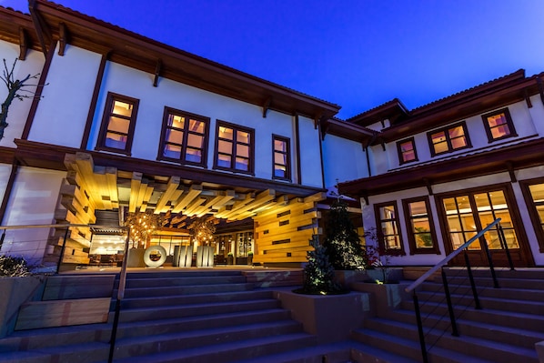 A multi-story building with a wooden facade, large windows, and a staircase leading to the entrance. - Omm Inn (Eskisehir)
