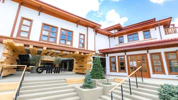 A building with a wooden facade, large windows, and a staircase leading to the entrance.